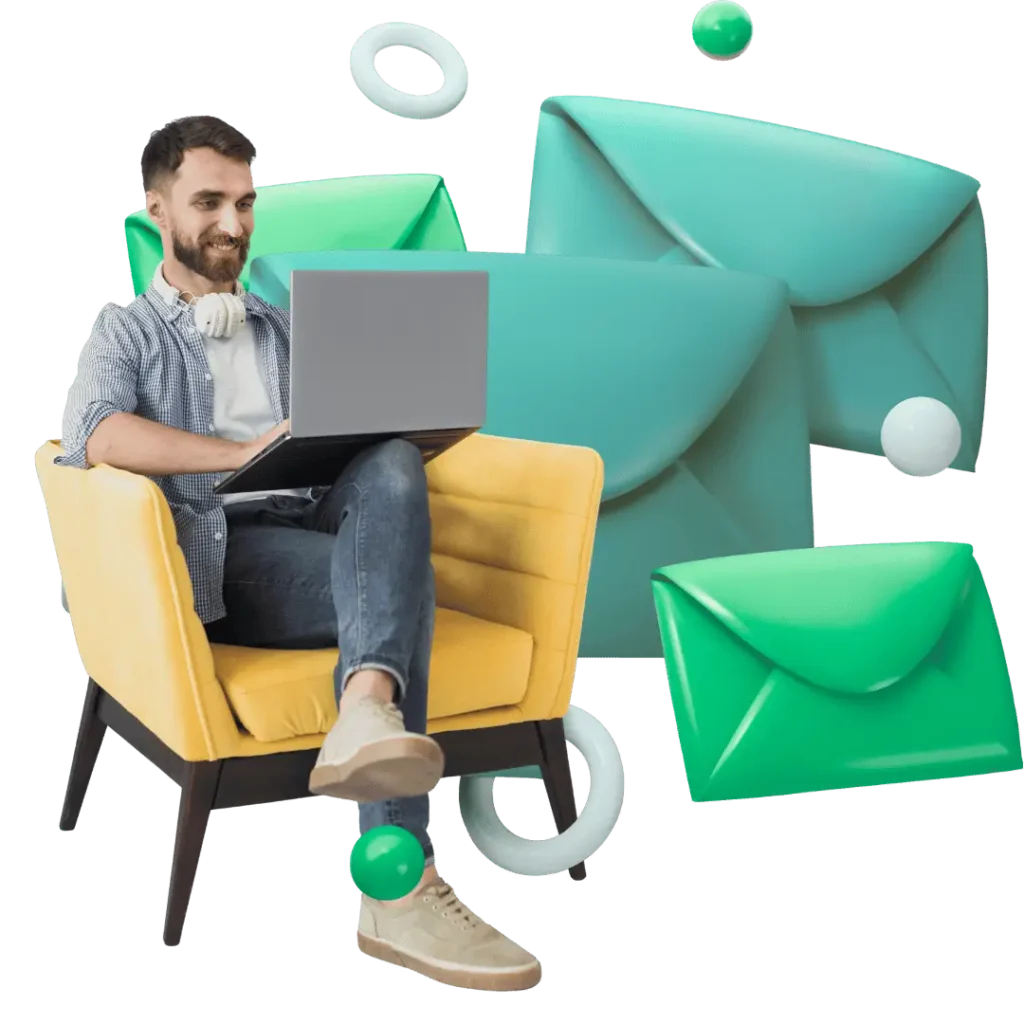 A smiling man with headphones on his neck sits comfortably in a chair, working on a laptop, surrounded by large 3D email envelopes and digital elements