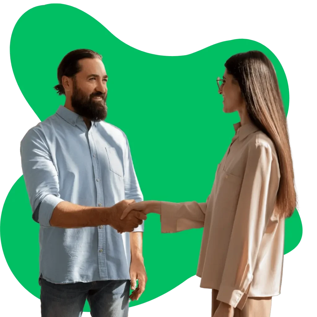 A man with a beard and a woman in glasses smiling and shaking hands