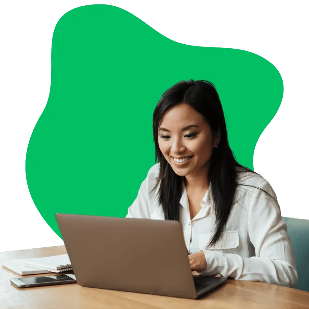 smiling woman working on a laptop at a desk, representing a satisfied user of our fast and reliable web hosting platform