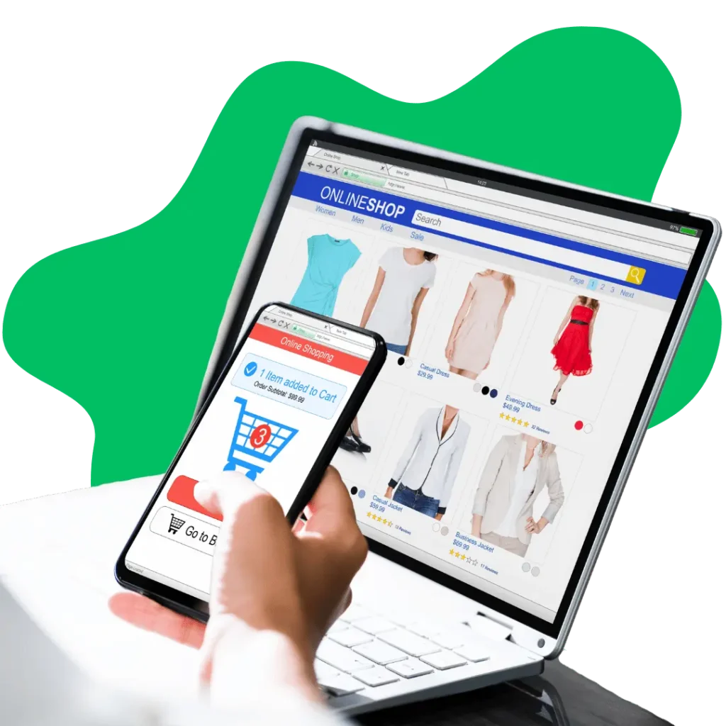 A person holding a smartphone showing an item added to a shopping cart, with a laptop in the background displaying an online clothing store.
