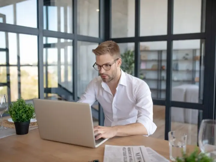 Man working on laptop in modern office setting, focusing on digital marketing strategies and SEO optimization